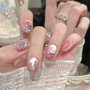 Pink cat-eye press-on nails with silver butterfly charms and glittering crescent moon design