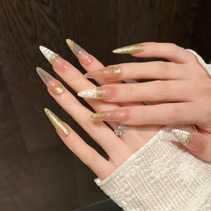Golden glitter stiletto press-on nails with white marble pattern and pearl accents