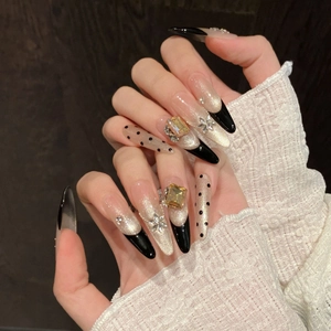 Faux ongles stiletto longs avec pointes noires French, base œil de chat pailletée et fleurs 3D