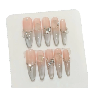 Handmade stiletto press-on nails with pink cat eye effect, pearls, and rhinestones