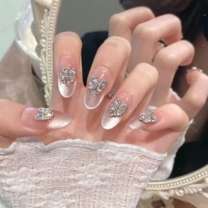 Handmade pink cat eye press-on nails with butterfly rhinestones in oval shape