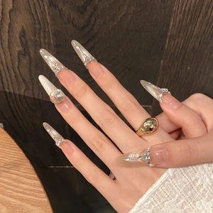 Faux ongles amande longs avec dégradé nude œil de chat, strass et bague dorée