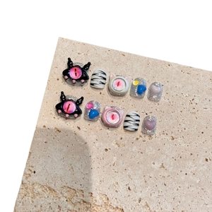 Cute monster-themed press-on nails with 3D eyes and zebra patterns on stone base