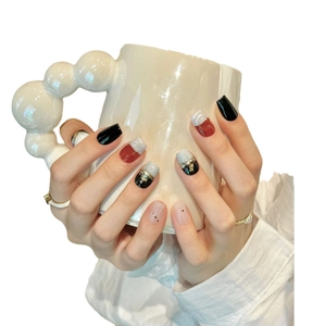 Handmade press-on nails with dark marble design and gold foil accents in short square shape