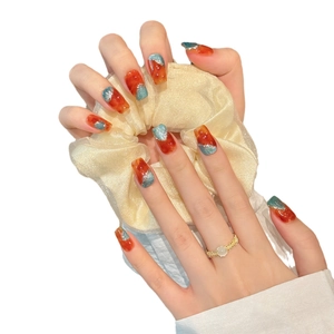 Faux ongles longs forme cercueil avec marbrure ambre et paillettes bleues brillantes