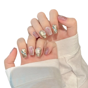 Handmade press-on nails with gold brushed texture, purple glitter, and sparkling rhinestones