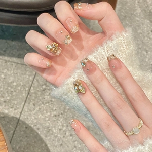 Unghie sfumate francesi rosa nude con glitter dorati e strass a fiocco 3D