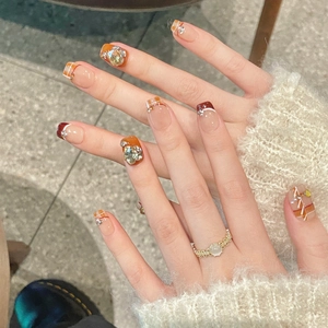 Handmade brown plaid press-on nails with amber tones and sparkling rhinestone accents