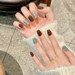 Blue plaid and deep brown square-round press-on nails shown on a hand with fuzzy sweater