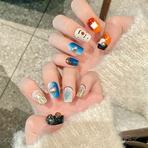 Faux ongles faits main dégradé bleu et orange avec perles métalliques et motifs abstraits