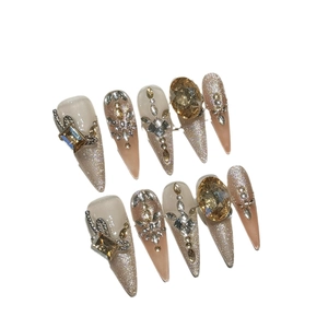 Luxurious handmade press-on nails in champagne glitter with rhinestones and pearls