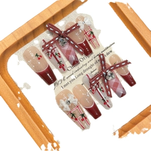Handmade burgundy and pink press-on nails with cherry patterns and 3D ribbon bows