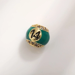 Macro shot of green enamel billiard ball charm with number 14 and cubic zirconia