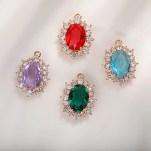 Close-up of sparkling oval emerald-cut crystal pendants with small zircon halo in gold setting