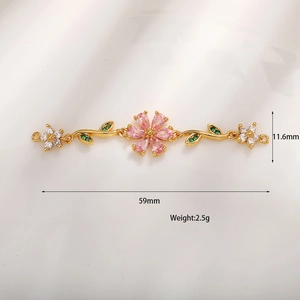 Macro di gioiello a fiore dorato da 59 mm con zirconia rosa e dettagli di foglie verdi