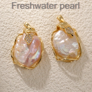 Macro shot of baroque freshwater pearl pendants with gold leaf design and pavé zircons