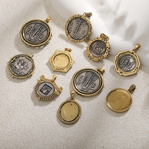 Detailed flat lay of antique gold coin pendants with Greco-Roman relief motifs on stone
