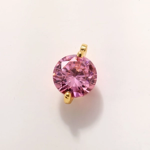 Detail of pink zircon planet charm in gold plated setting with double rings for jewelry making
