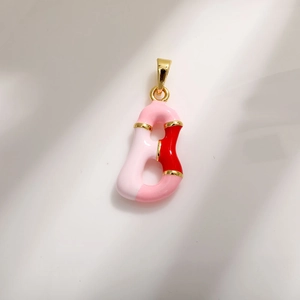 Macro detail of Letter B pendant with pink enamel and gold plating for DIY jewelry