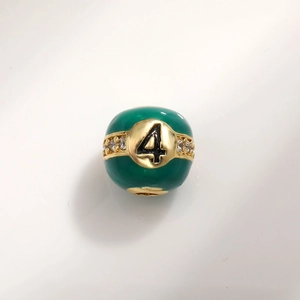 Detailed macro view of number 4 green enamel charm bead with gold plating and white zircons