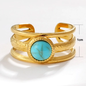 Détail d'un anneau évidé doré de 1cm de large avec une pierre centrale turquoise