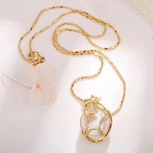 Detail of baroque pearl necklace with golden ginkgo leaf and bamboo style chain