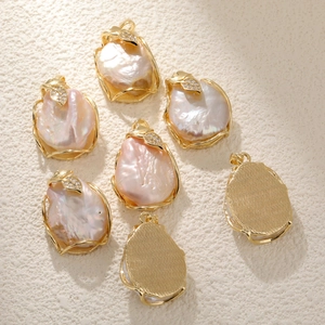 Detailed macro view of baroque pearl pendants with gold leaf bail and crystal accents