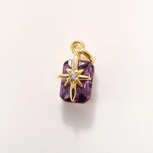 Detailed close-up of purple crystal pendant with gold starburst and white zircon inlay