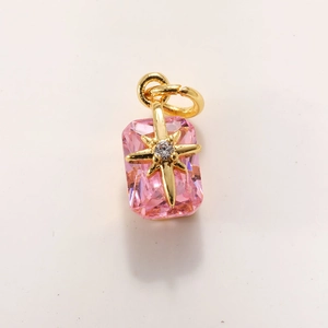 Detail of a pink rectangular crystal pendant with a gold starburst and zircon center