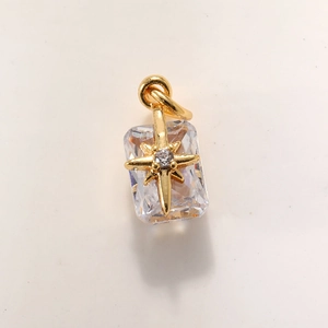 Macro shot of rectangular zircon planet pendant with star detail and gold plated ring