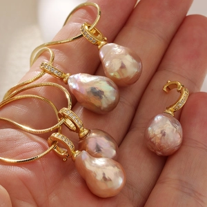 Vue macro de pendentifs en perles baroques avec fermoirs en zircon et chaînes serpent dorées