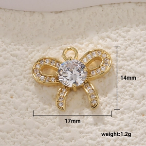 Macro shot of gold bow pendant with white zircons measuring 17mm x 14mm and weighing 1.2g