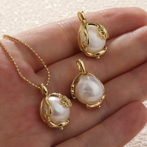 Detailed macro view of baroque pearl pendants with ornate gold filigree floral settings