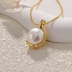 Macro detail of a baroque freshwater pearl pendant with a gold-plated crescent setting