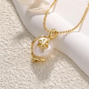 Macro view of a large white baroque pearl pendant with gold flower cap on a bead chain