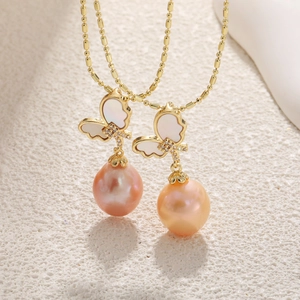 Elegant gold butterfly necklace with baroque pearls and rose motifs on a white surface