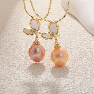 Detail of butterfly pendant with baroque pearl, mother of pearl inlay and gold plating