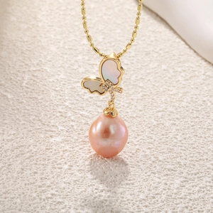 Macro detail of butterfly pendant with baroque pearl and golden beaded chain
