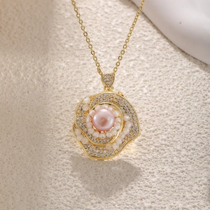 Detailed macro view of a gold flower pendant with a pink pearl and white zircons