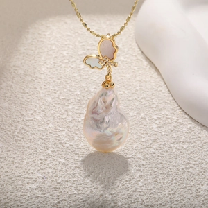 Close-up of baroque pearl necklace with mother-of-pearl butterfly and zircon details