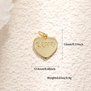Vista dettagliata di un ciondolo a cuore placcato oro con incisione LOVE e misura 13mm