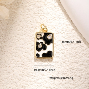 Détail d'un pendentif rectangulaire plaqué or avec émail et accents de zircon