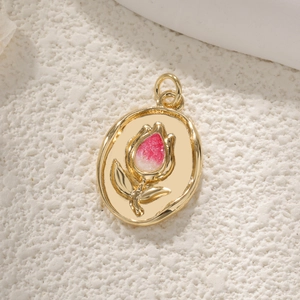 Detailed macro view of an oval tulip pendant with pink glitter enamel and gold plating