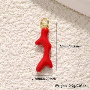 Macro detail of red coral enamel charm with gold loop showing dimensions 22mm by 7.3mm