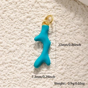Macro view of blue coral-shaped pendant with gold ring on white textured background