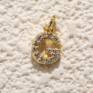 Macro-opname van 18k vergulde letter G-bedel met zirkonia voor DIY-sieraden maken