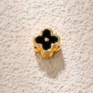 Detail of a four-leaf clover gold-plated charm with black enamel for jewelry making