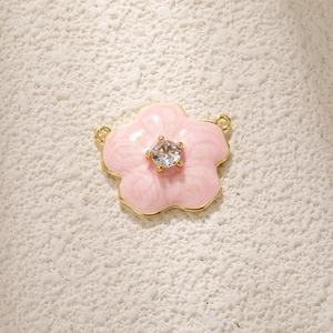 Macro detail of pink daisy flower charm with cubic zirconia and gold-plated connectors