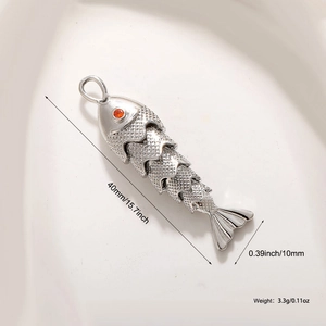 Makroaufnahme von silbernem Koi-Fisch-Anhänger mit rotem Zirkonia-Auge und Schuppen