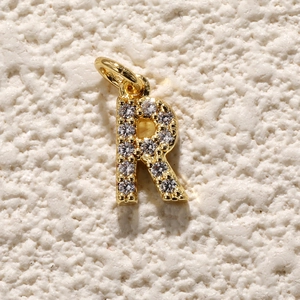 Detail van de goudkleurige letter R bedel met schitterende zirkonia stenen inleg